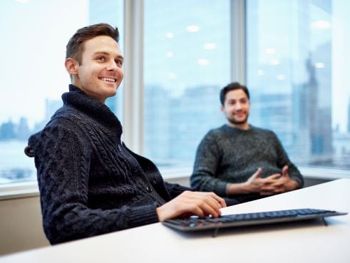 Two colleagues talking at a computer