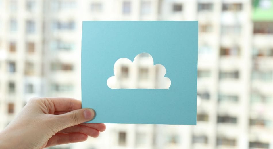 Hand holding a blue card with a cloud cut-out