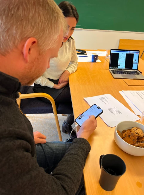 A user tests a prototype of the audit database on a mobile phone during a user test